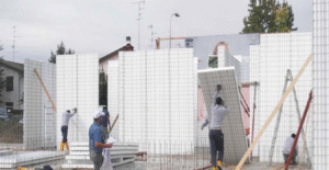 Avance en la construcción con sistemas modernos y sostenibles: trabajadores instalan paneles prefabricados para optimizar tiempos y recursos en obra.