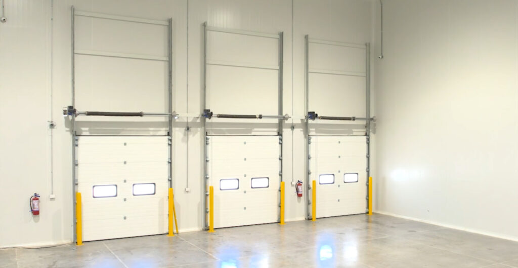 Puertas de muelle en cuarto frío industrial con aislamiento térmico eficiente para almacenamiento y logística.