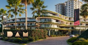 Fachada moderna de un edificio de usos mixtos rodeado de palmeras, con diseño curvo, terrazas ajardinadas y letrero frontal con las siglas “DAM”, representando un desarrollo urbano sustentable y de alta rentabilidad.